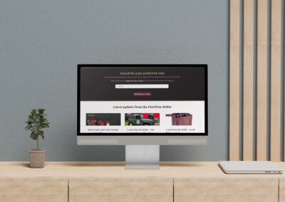 FineWine search tool and blog feed in website mockup on computer on modern office desk smaller