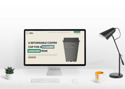 Trim Community Cup computer desk mockupof the website by DesignBurst for web () ()